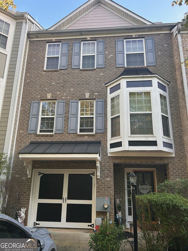 view of property with brick siding and a garage