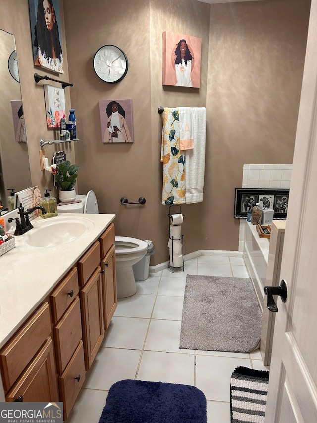 full bathroom featuring tile patterned flooring, baseboards, toilet, a bath, and vanity