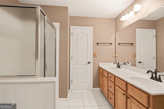 full bath featuring a sink, a stall shower, double vanity, and tile patterned flooring