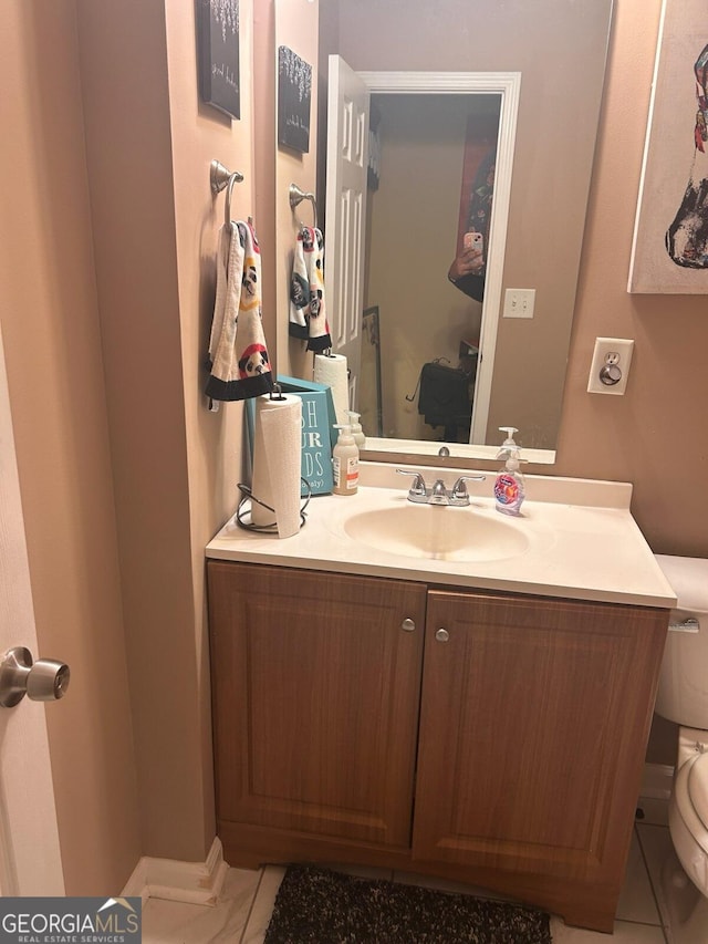 half bathroom featuring vanity and toilet