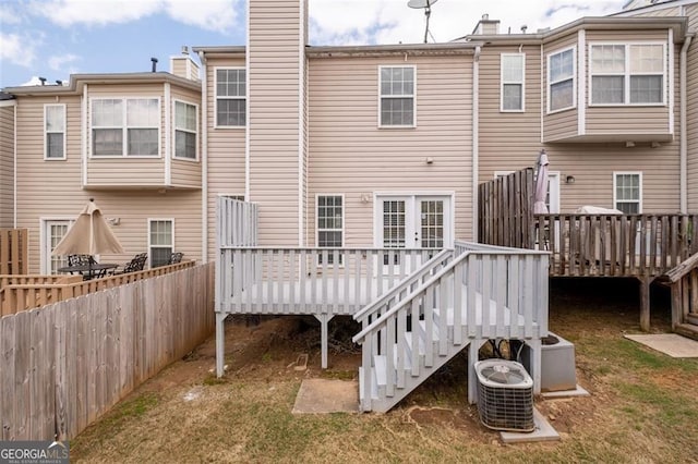 rear view of property featuring a deck, central air condition unit, fence, and a chimney