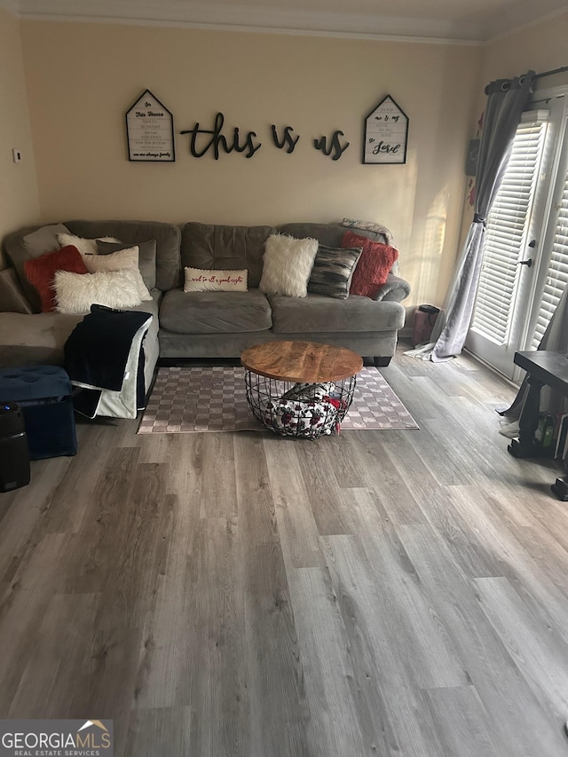 living room with wood finished floors and ornamental molding