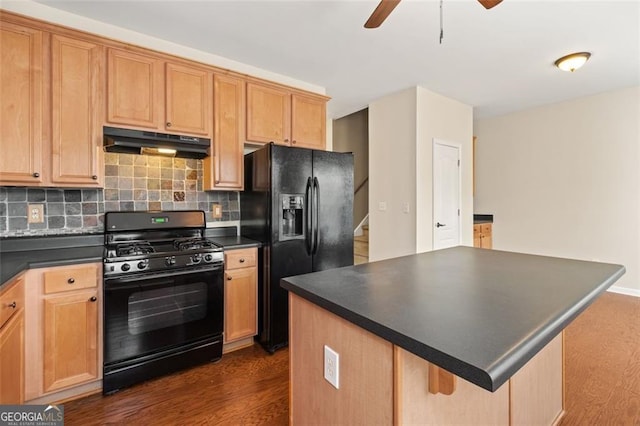 kitchen featuring black appliances, under cabinet range hood, dark countertops, ceiling fan, and dark wood-style flooring