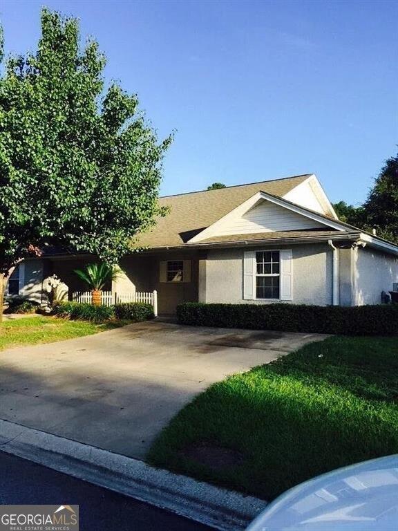 single story home with driveway and a front lawn