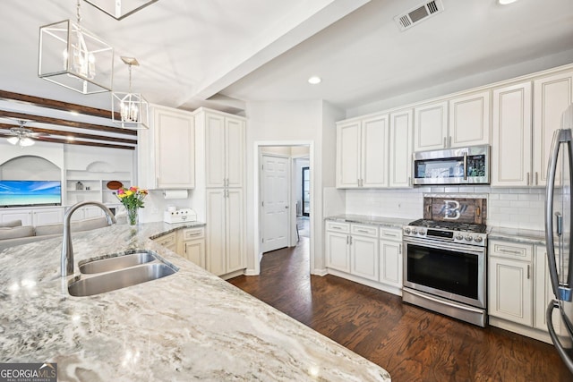 kitchen featuring visible vents, light stone countertops, beamed ceiling, appliances with stainless steel finishes, and a sink