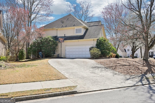 view of front facade with a front yard, an attached garage, driveway, and a shingled roof