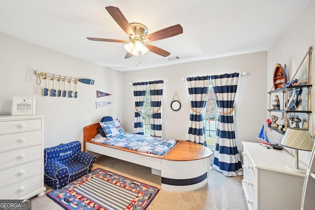 carpeted bedroom featuring a ceiling fan and visible vents