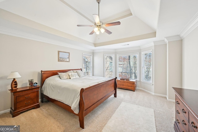 bedroom with crown molding, baseboards, a tray ceiling, light carpet, and a ceiling fan