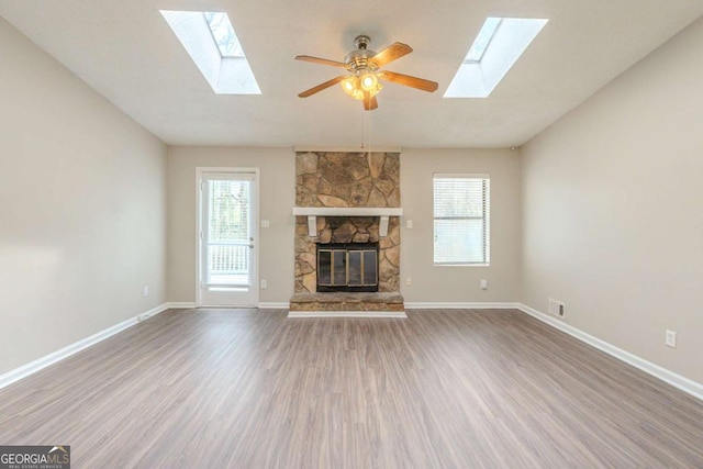 unfurnished living room featuring wood finished floors, a fireplace, and lofted ceiling