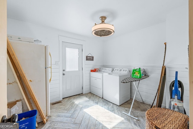 laundry area featuring a wainscoted wall, laundry area, visible vents, and independent washer and dryer