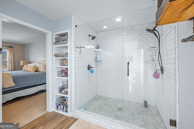 bathroom featuring a shower stall, ensuite bath, and wood finished floors