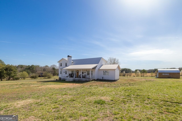 view of front of house with a chimney, a porch, and a front yard