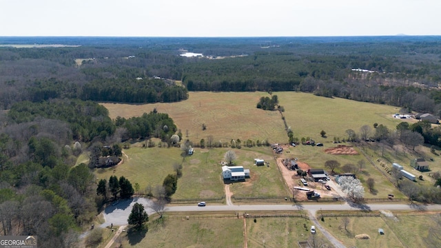 birds eye view of property featuring a rural view and a wooded view