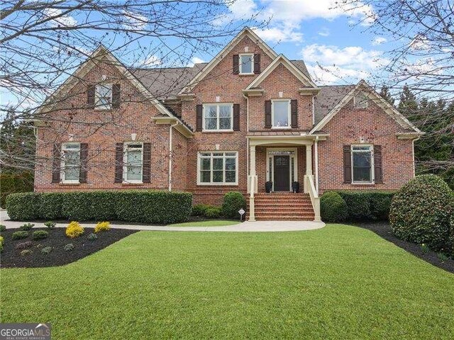 view of front of home with brick siding and a front lawn