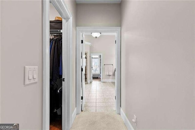 hall with light tile patterned floors and baseboards