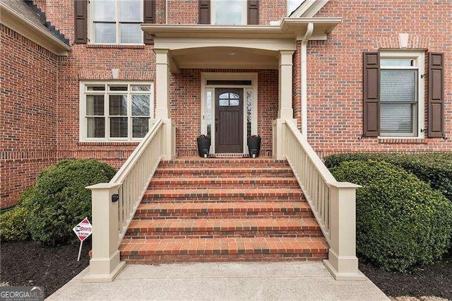 view of exterior entry with brick siding