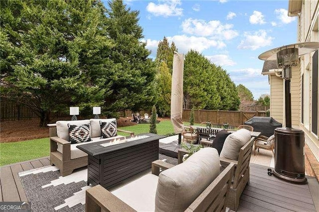 wooden deck with an outdoor living space with a fire pit and a fenced backyard