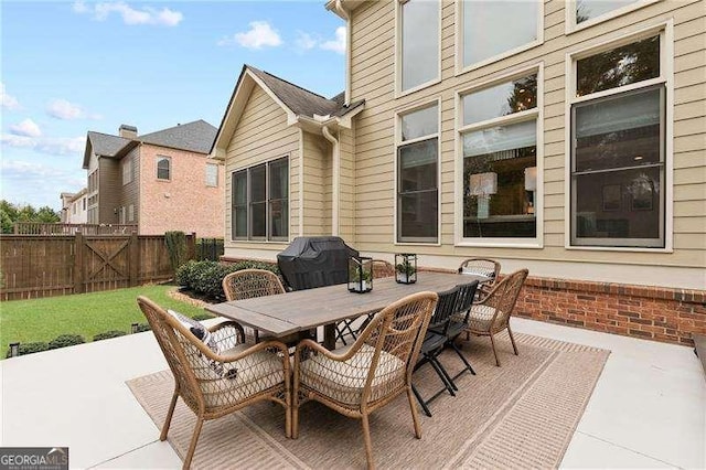 view of patio with outdoor dining area, grilling area, and fence