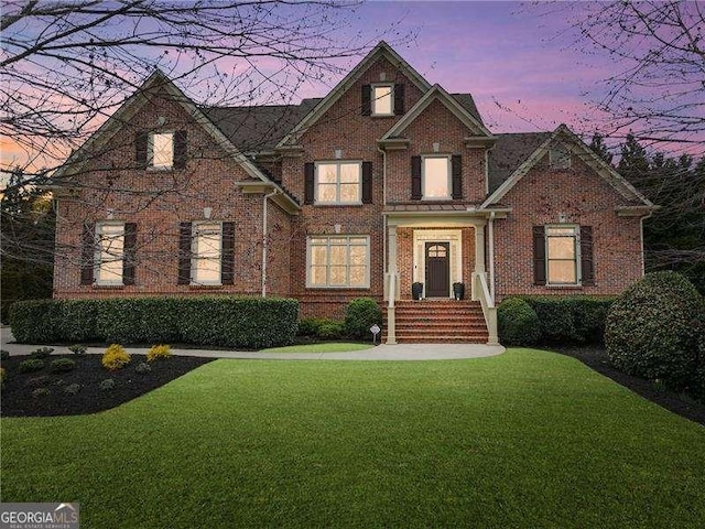 view of front of property with brick siding and a front yard