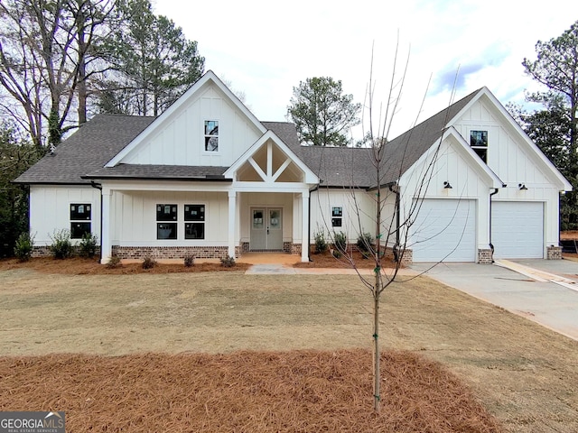 modern farmhouse style home featuring a garage, board and batten siding, concrete driveway, and roof with shingles