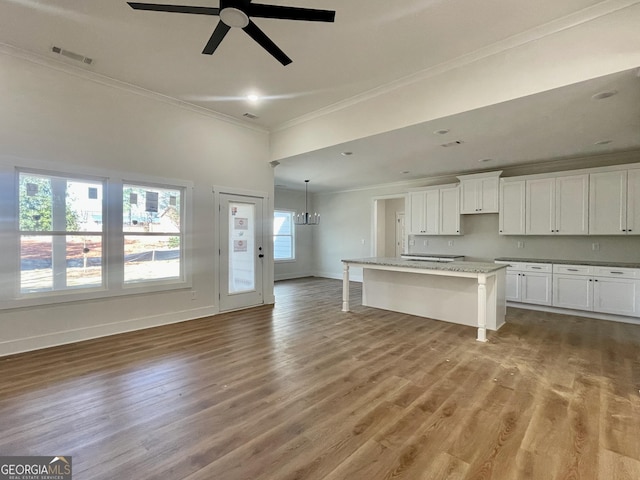 kitchen featuring visible vents, crown molding, and wood finished floors