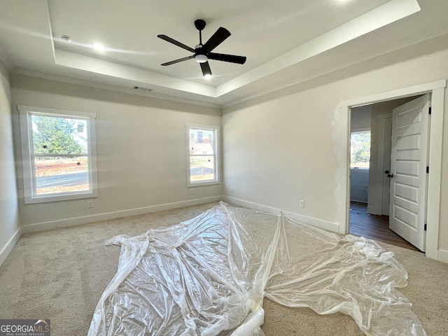 bedroom featuring carpet, a raised ceiling, and baseboards