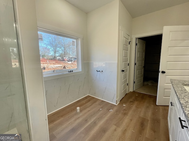 laundry area featuring wainscoting and wood finished floors