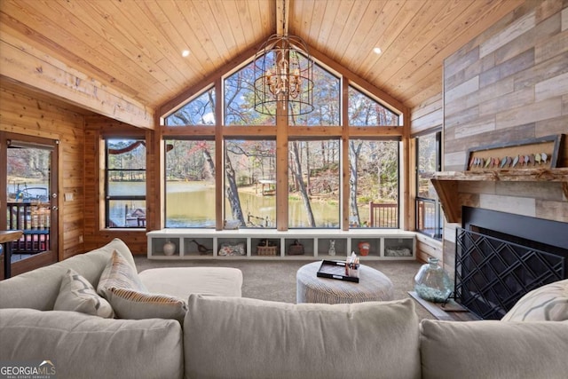 carpeted living area with high vaulted ceiling, wood walls, wood ceiling, and an inviting chandelier