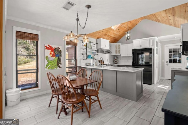 dining area with visible vents, baseboards, crown molding, and lofted ceiling