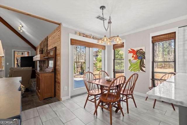 dining area featuring visible vents, baseboards, lofted ceiling, crown molding, and a notable chandelier