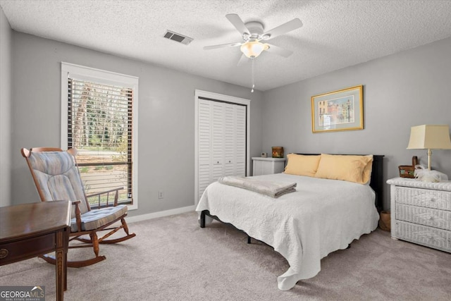 bedroom with visible vents, baseboards, light carpet, a closet, and a ceiling fan