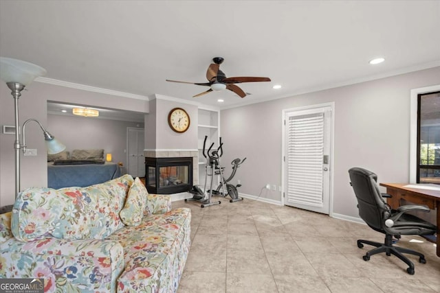 living room with a tiled fireplace, a ceiling fan, baseboards, and ornamental molding