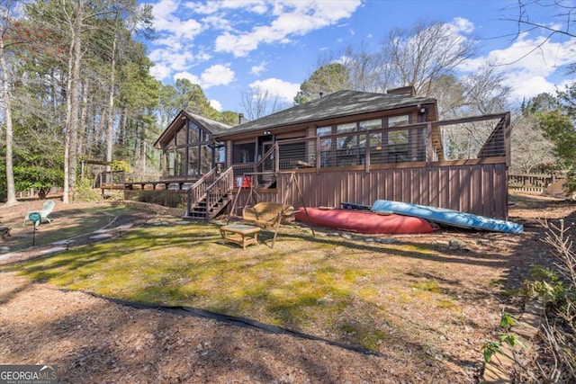 rear view of house with a deck, stairs, and a sunroom