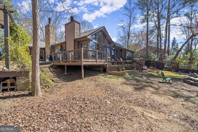 rear view of property with a wooden deck and a chimney