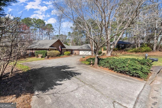 view of front of home featuring fence, a garage, and driveway