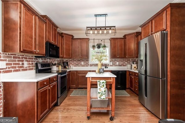 kitchen featuring black appliances, ornamental molding, and light wood finished floors