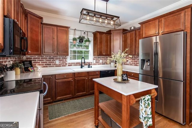 kitchen featuring a sink, black appliances, light wood-style flooring, and crown molding