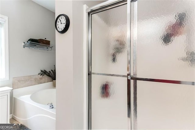 bathroom featuring a garden tub and a stall shower