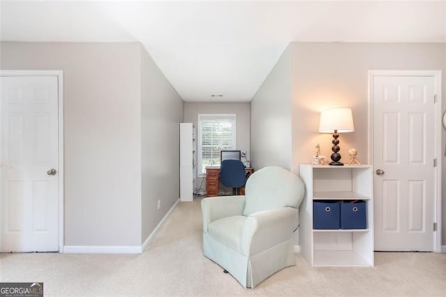 living area with light colored carpet and baseboards