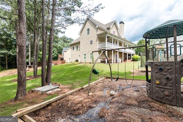 exterior space with a lawn, a chimney, and a playground