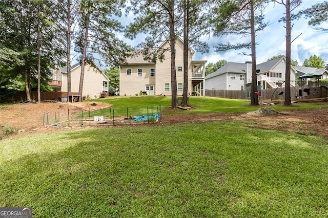 view of yard featuring a residential view, a vegetable garden, and fence