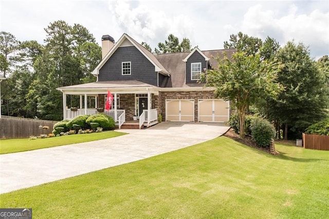 view of front of property with driveway, stone siding, a porch, fence, and a front yard