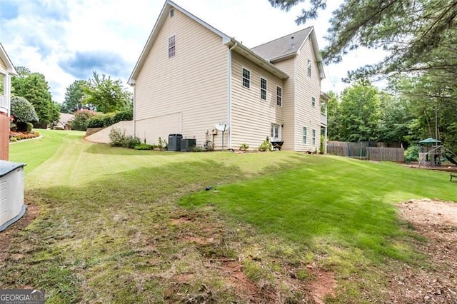 rear view of property featuring a yard, cooling unit, and fence