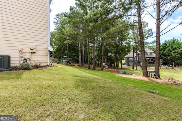 view of yard with central AC unit and fence