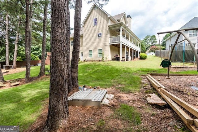 back of property featuring ceiling fan, a yard, and fence