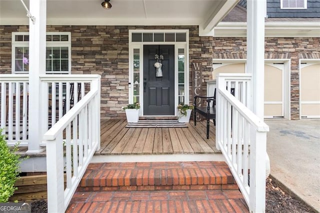 view of exterior entry with stone siding, a porch, and visible vents