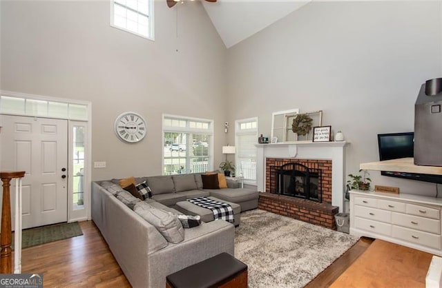 living area featuring a wealth of natural light, wood finished floors, ceiling fan, and a fireplace