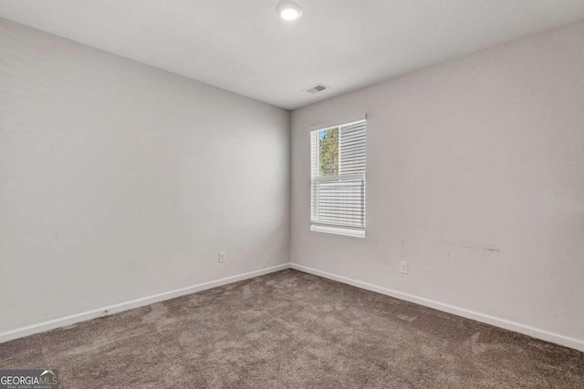 carpeted spare room featuring baseboards and visible vents