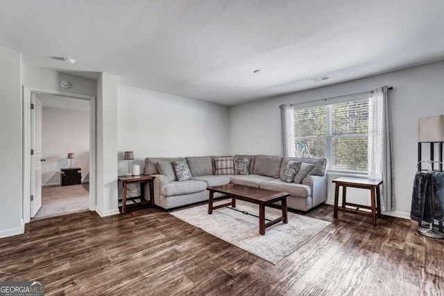 living room with dark wood-style floors, visible vents, and baseboards