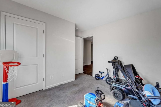 workout area with baseboards and carpet floors